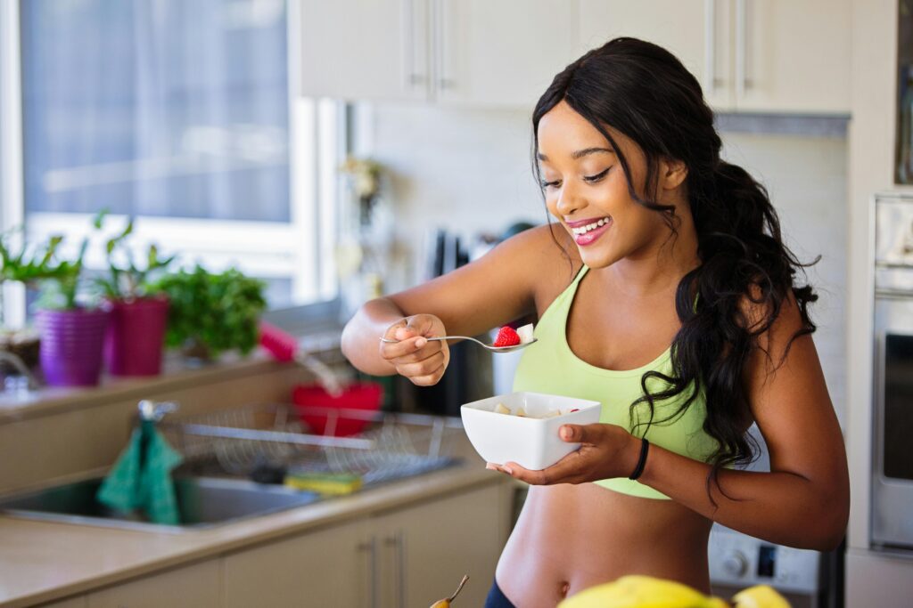 a woman eating a bowl of fruit